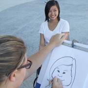 Diana Lin, 21, accounting major sits for Kelcie Gruenberg who has been drawing caricatures for nine years. Students were given the opportunity to be drawn for free during the Hawaiian themed Matafest at the USU on Wednesday. Photo Credit: Mariela Molina / Visual Editor