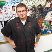 Murals Jake Prendez, 35-year-old Chicana/o studies graduate student, stands alongside a mural he contributed to in Jerome Richfield Hall room 130. Photo Credit: Tessie Navarro / Visual Editor