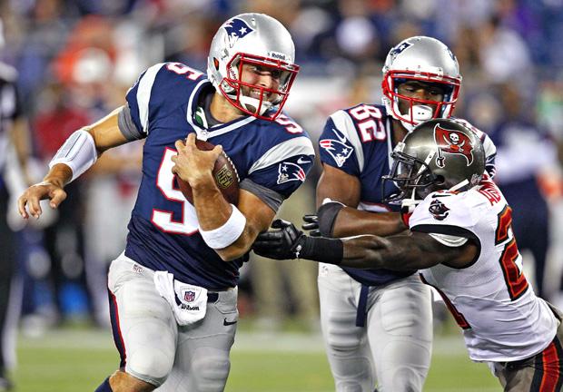 Former New England Patriots quarterback Tim Tebow eludes a Tampa Bay Bucaneers defender in a recent preseason game. Photo courtesy of MCT