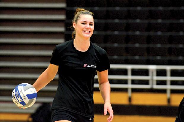 Junior middle blocker Casey Hinger carries a ball after drills at Wednesday's women's volleyball practice. The psychology and child development double major is also a captain for the squad with NCAA tournament hopes