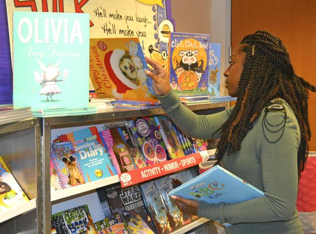 Deanecia Wright, 27, education leadership graduate student, considers which book to purchase for her niece at the Scholastic Book Fair. The book fair will be ongoing until Friday, Oct. 11, 9 a.m. to 4 p.m. Photo credit: Victoria Becerril / Daily Sundial