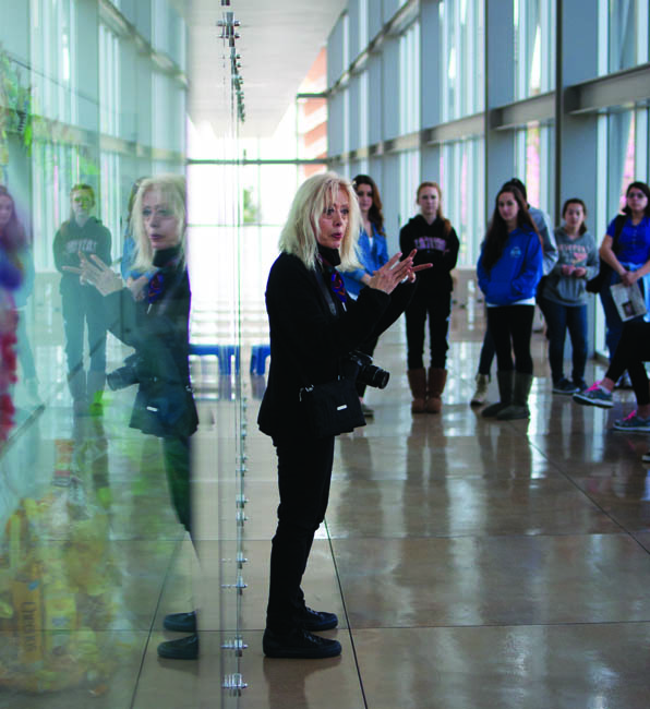 Professor Edie Pistolesi talks to her art 100 students in front of the installation's glass case in Manzanita Hall. Photo by David Hawkins/photo editor