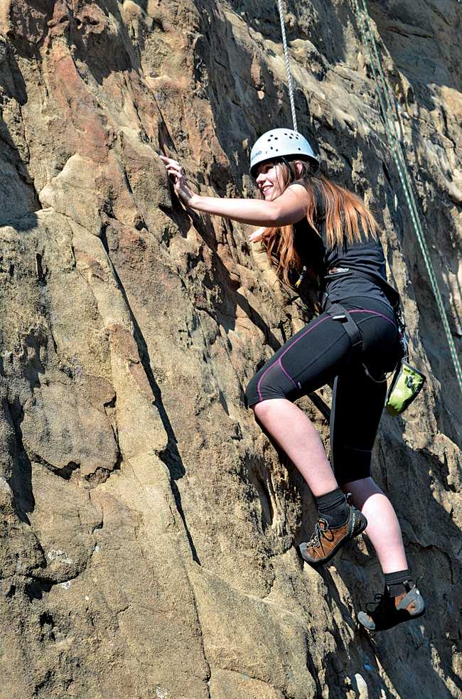 CSUN student Lindsay Barney analyzes her next move up the wall at the beginning of her first climb. (Photo Credit: Christian Akers/Contributor)