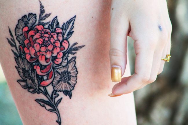 Carli LoCicero, 25, shows off her brand new tattoo made up of Chrysanthemums and Poppies. (Ashley Grant/ The Sundial)