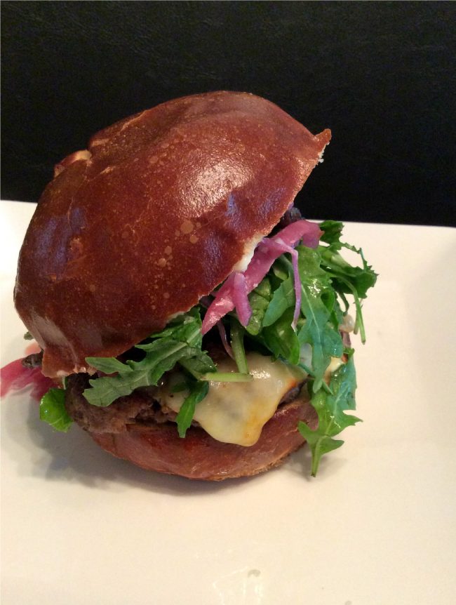 Oi Burger, $9, consists of an angus beef burger, pickled red onions, truffled balsamic shiitake mushrooms, muenster cheese, mayo, arugula and a pretzel bun. (Genna Gold/ The Sundial)
