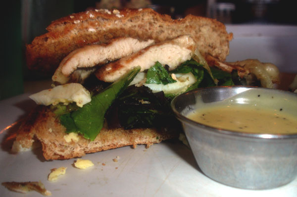 A grilled, one-third pound chicken burger on a honey wheat bun with sharp provolone cheese, hard-boiled eggs and mixed baby greens with honey mustard sauce on the side. Photo Credit: Jaclyn Rymer / Staff Reporter