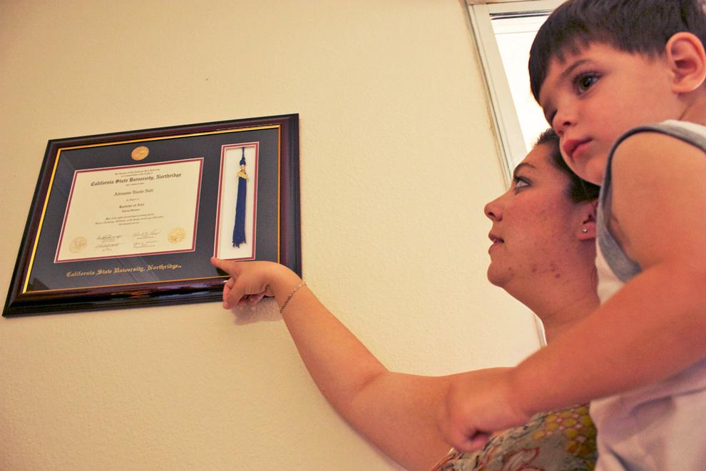Adrianne Lord, a 2010 CSUN almuna holds her two-year-old son, Tyler, and points to her bachelor's degree diploma. She will be paying for the student loans she acquired to pay off her education for the next 10 years. Photo Credit: A.J. Circhirillo / Daily Sundial