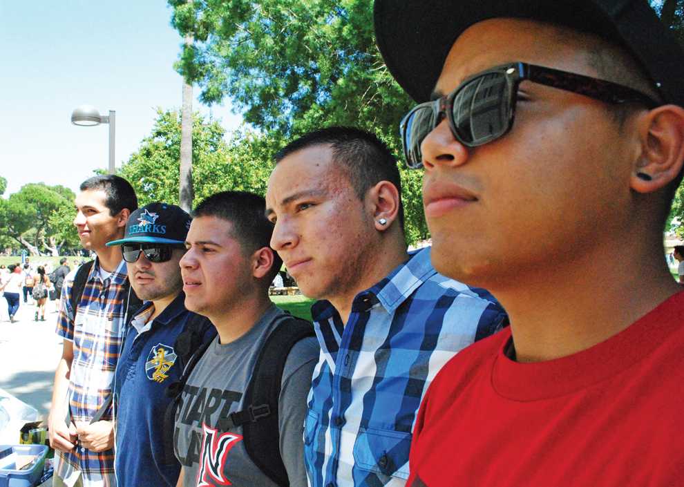 The Hermanos Unidos de CSUN stand in front of their booth on the first day of class, helping lost students find their way around CSUN. 