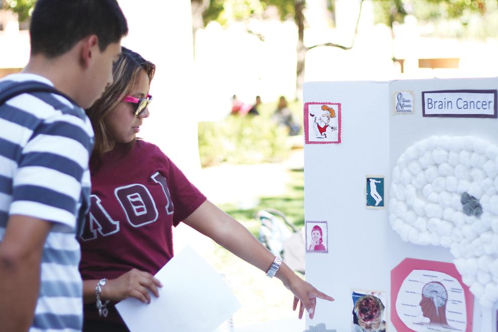 Jennifer Yessi of the Lambda Theta Alpha Sorority talks to a student about brain cancer and tumors during the Greeks Against Cancer event. Simon Gambaryan / Daily Sundial