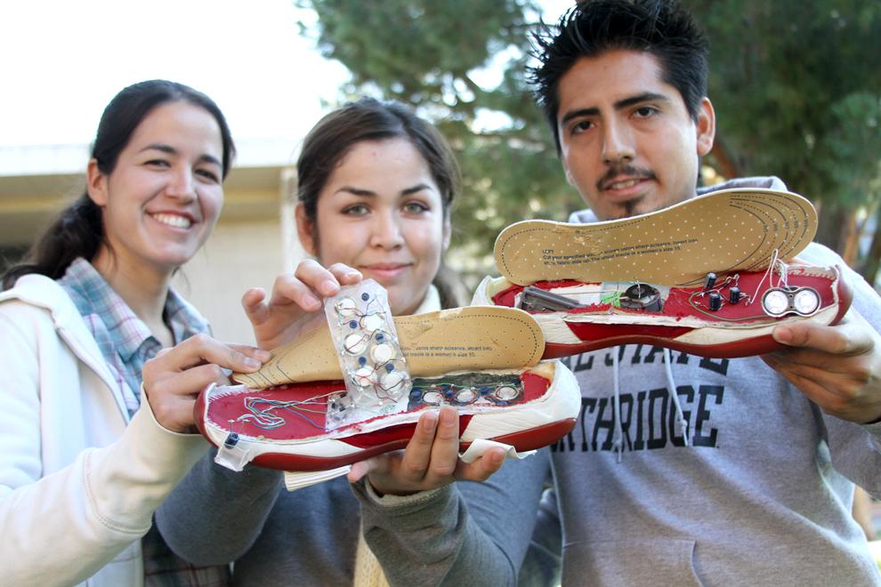 Melissa Martinez, senior civil engineering major, Ana Avelar, senior engineering major, and Eliud Munguia, senior computer science major, hold up their Powered Footwear prototype which won second place at the Society of Hispanic Engineers conference in Anaheim in October. Photo Credit: Tessie Navarro / Visual Editor
