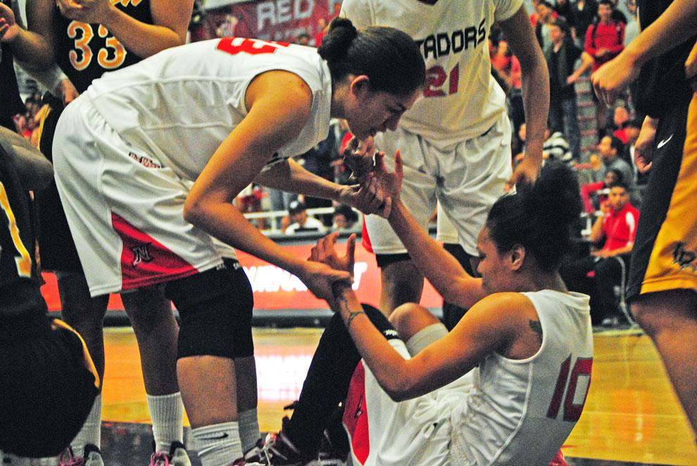 Matador forward Violet Alama helps teammate Janae Sharpe up after she was fouled during CSUN’s game against LBSU on March 6. CSUN had time off and is now prepared to face USD in the WNIT Friday. Photo Credit: Andres Aguila / Daily Sundial