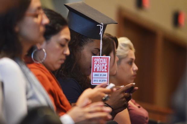 Some SQE members came with home-made graduation caps of construction paper featuring the price tag of education in 2012 compared to 2002. Photo credit: Ken Scarboro / Senior Photographer