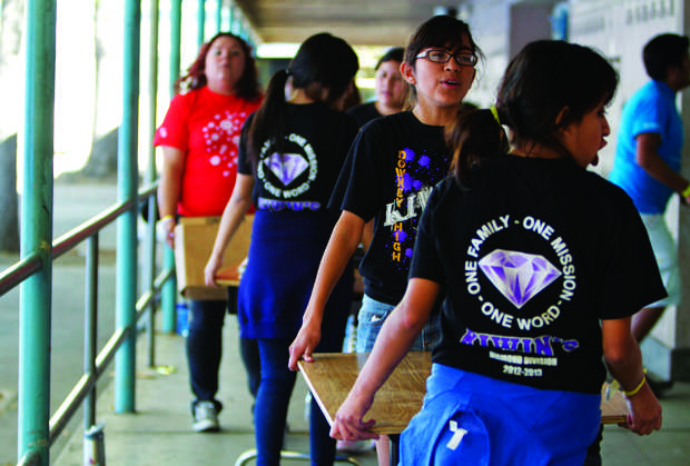 Students and volunteers help clear out old furniture and outdated textbooks from a classroom at Washington Irving Middle School. Over 1,000 volunteers joined to help beautify the campus as it transitions to being a magnet. Photo Credit: Charlie Kaijo / Senior Photographer