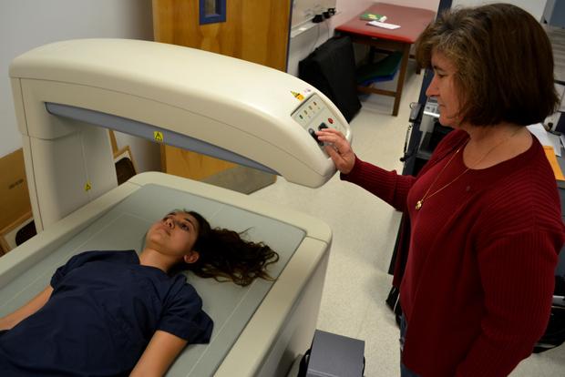 Dr. Victoria Jacque (R), associate professor and graduate coordinator for the kinesiology graduate program, conducts a lumbar spine scan using the DEXA Body Scanner on Alene Ashjian (L), 21, a kinesiology major, to determine mineral density. Photo Credit by John Saringo-Rodriguez / Daily Sundial