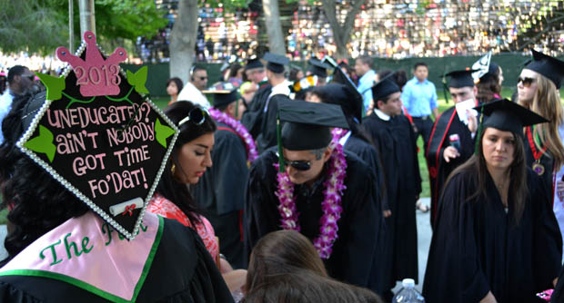 The College of Health and Human Development students gathered on the Oviatt Lawn minutes before taking their seats for their commencement ceremony.  Many graduates customized their caps to fit their personalities and while doing so they made sure that they were easily spotted from a distance.  Photo credit: John Saringo-Rodriguez / Photo Editor