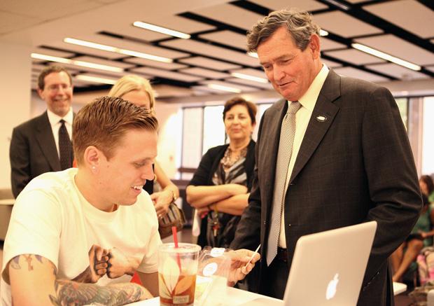 CSU Chancellor Timothy White gives Robert Querfurth, 23, a business marketing major his card after introducing himself in the Oviatt Library during his campus tour. Photo credit: Loren Townsley/ Editor in Chief