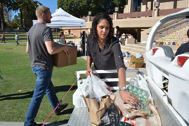 Community Engagement's service learning coordinator, Nicole Linton, helps unpack donated goods for the clothing and food drive event. "This is my first time...It's really great to see the outcome," Linton said. Photo credit: John Saringo-Rodriguez / Photo Editor
