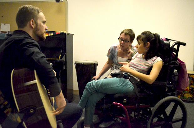 Julie Berghofer, assistant director of the CSUN music therapy clinic, and Scott Whelan, 25, junior music therapy major, use music to help a disabled patient at the clinic on Thursday, Nov. 14, 2013. Photo credit: Alex Vejar / Daily Sundial