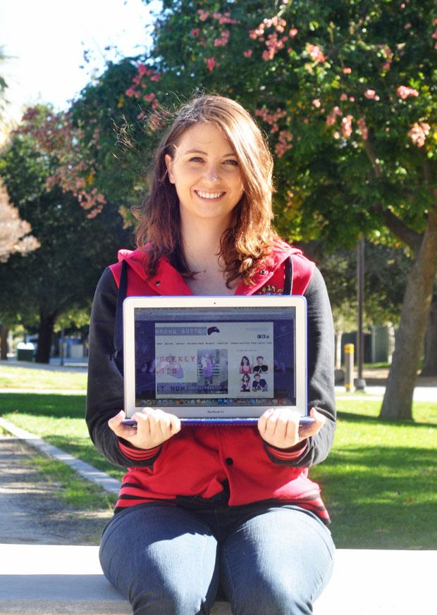 CSUN student Emily Kelley holds up her award-winning website on her laptop. Photo credit: Lisa Anderson / Daily Sundial