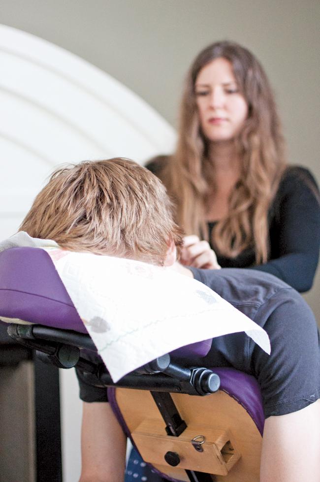 Quinn Miller, 20, sophomore finance major, receives a massage from Natalie Bresson a massage therapist at the Crunch Time event where students can release their stress a week before finals held at the USU Grand Salon on May 6, 2014. (Photo Credit: David J. Hawkins/Photo Editor)