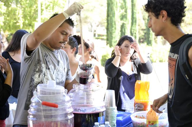Bryan Solares (left), junior psychology and Central American studies major, serves a drink to Daniel Bonilla (right), junior CTVA major during the EOP 45th celebration event on Sept. 16 on the Matador Bookstore lawn at CSUN. Photo Credit: Alex Vejar/ The Sundial