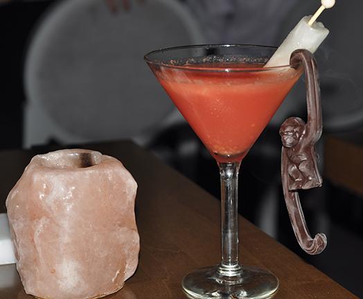 The Sabrinatini arrives infused with liquid nitrogen causing vapors to ascend over the sleek martini glass frame. The martini honors the restaurant owners' pet monkey, Sabrina, who passed away last year, with a dark chocolate monkey. Photo Credit:Natanya Toomes/The Sundial