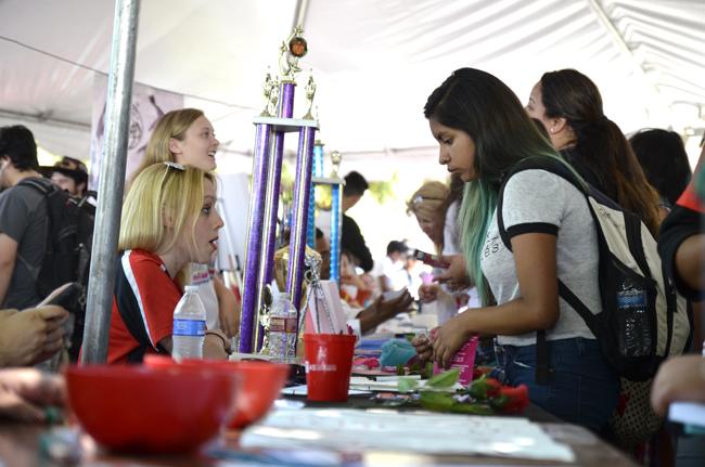 Richere Barbeau (left), 20, junior art major, gives information to Jasmine Santos, 19, freshman speech pathology major, during the Meet the Clubs event on Tuesday, Sept. 2, 2014 on Bayramian Lawn. Photo Credit: Alex Vejar/ The Sundial