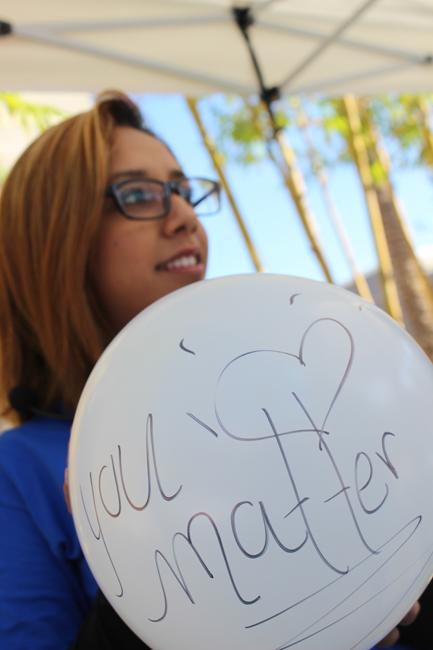 Blues Project member, Mayra Ruiz, 21, junior psychology major, writes her own inspirational saying on a ballon for the Beat the Blues Week at CSUN on Nov. 19. Photo Credit: Araceli Castillo/Photo Editor