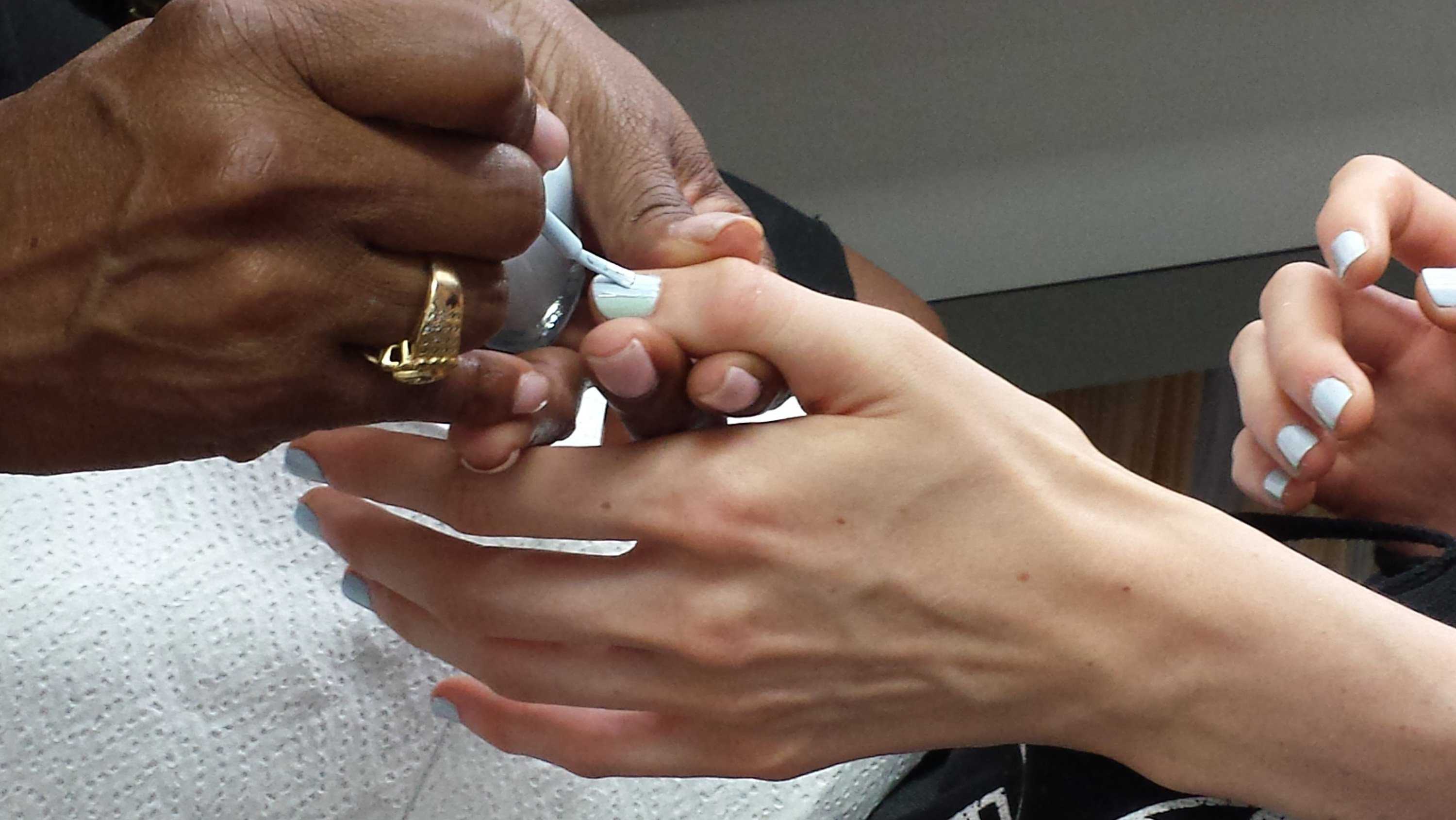 A nail technician polishes a models nails using a trio of pastel Zoya nail polishes.  (Sara Bauknecht/Pittsburgh Post-Gazette/MCT)