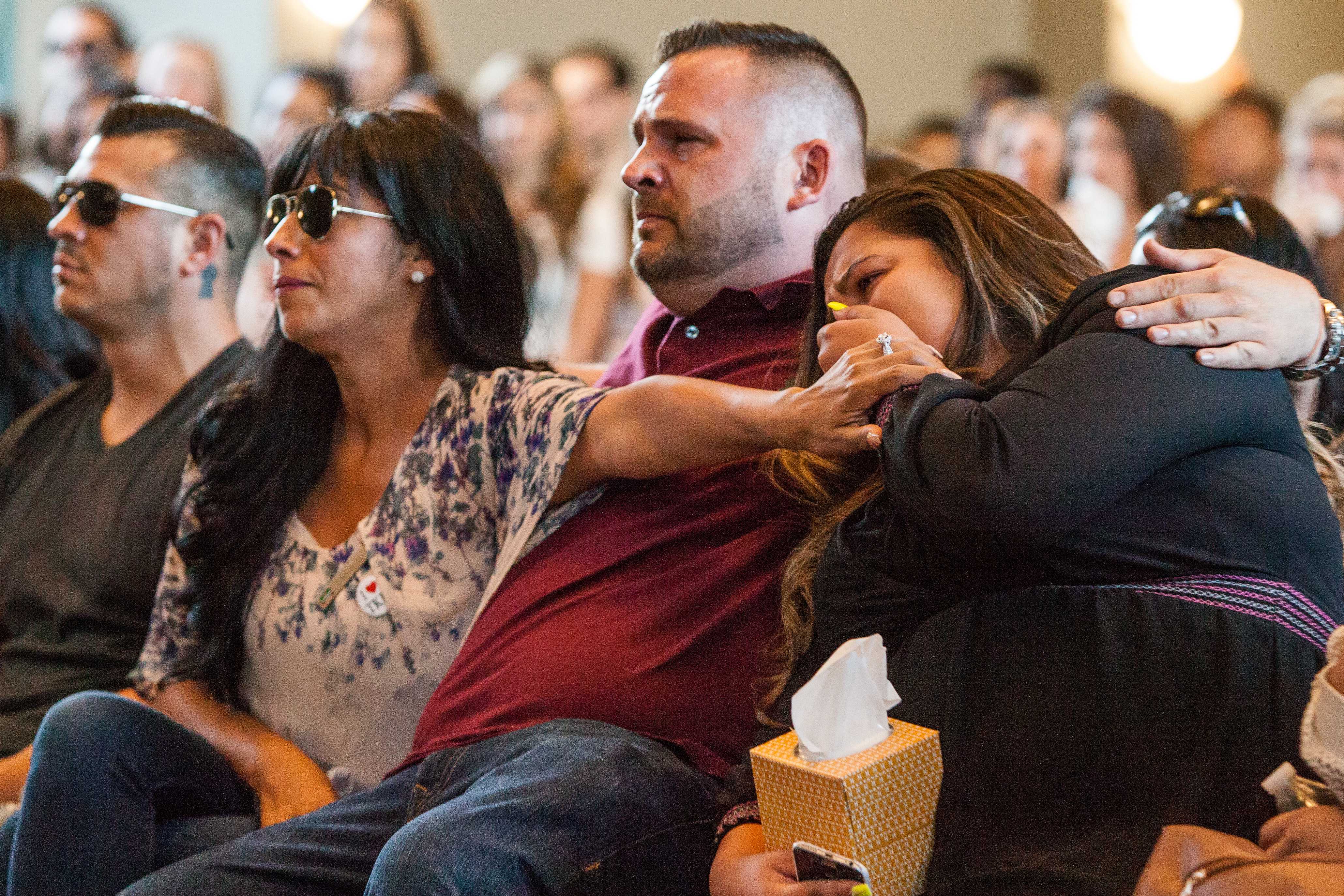 Monica Saucedo,  Desirae Crittenden's mother, comforts one of her children during a slideshow of images in memory of their family member.