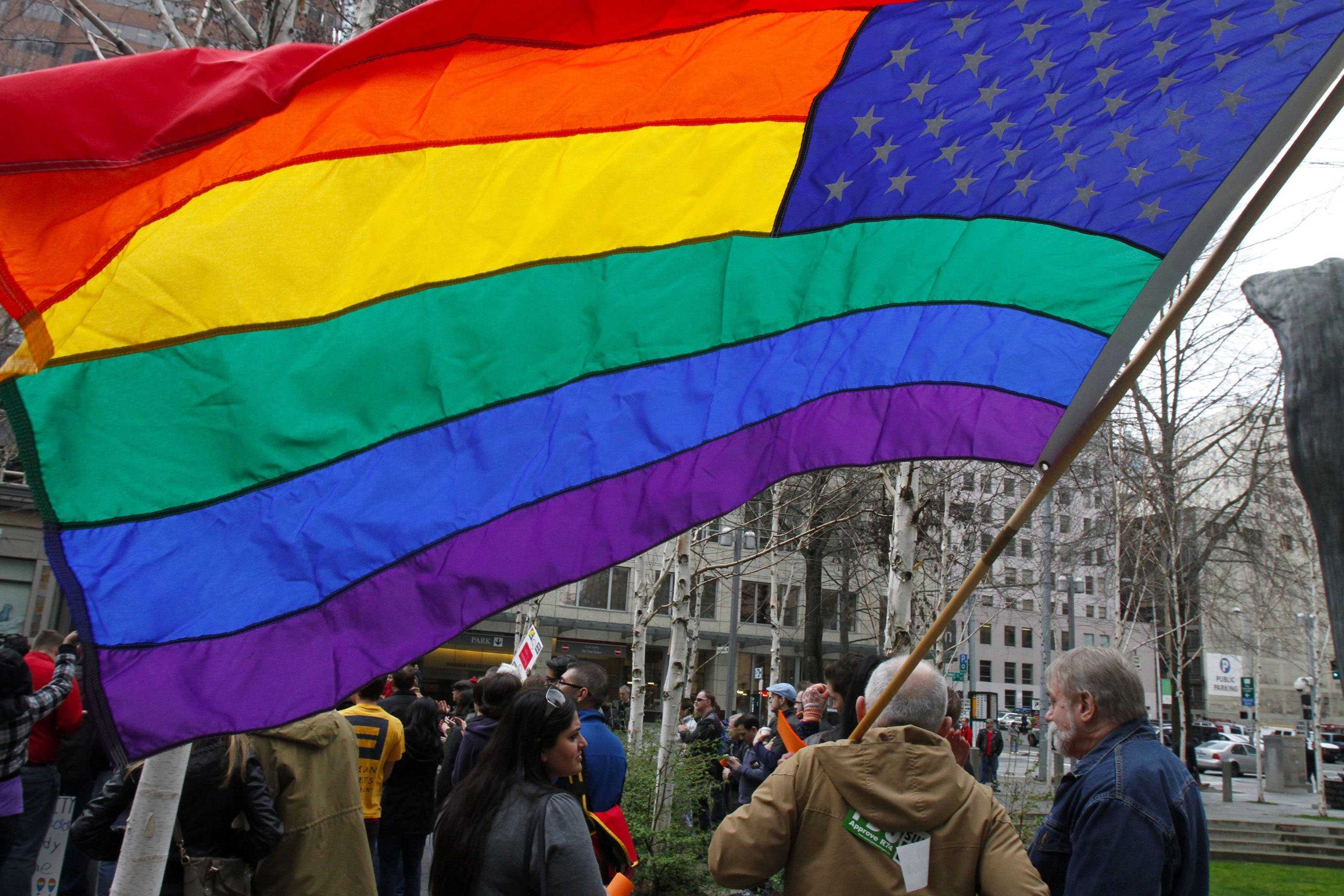 A gay-marriage supporter flies a rainbow flag during a rally in Seattle, Washington, in March, when the U.S. Supreme Court heard arguments in a case that led to federal recognition of same-sex marriages. (Greg Gilbert/Seattle Times/MCT)
