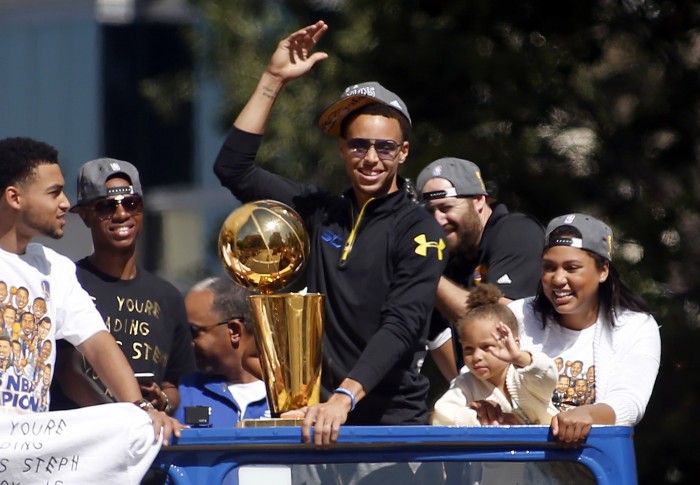 Stephen Curry basks in the glow of the Golden State Warriors NBA championship parade alongside his wife Ayesha and daughter Riley in downtown Oakland, Calif., on Friday, June 19, 2015. (Karl Mondon/Bay Area News Group/TNS)