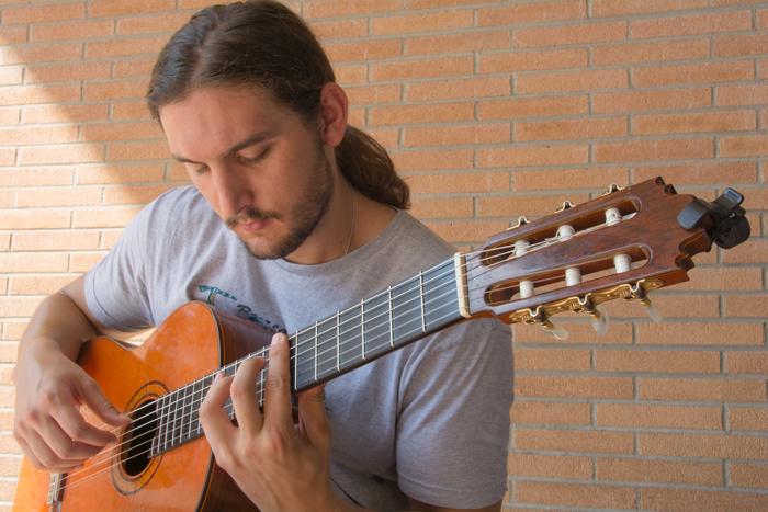Garrett+Bower+practices+the+classical+guitar+outside+of+Cypress+Hall+regularly.+The+23-year-old+senior+classical+guitar+performance+major+developed+an+ear+for+music+when+he+was+just+10+years+old.