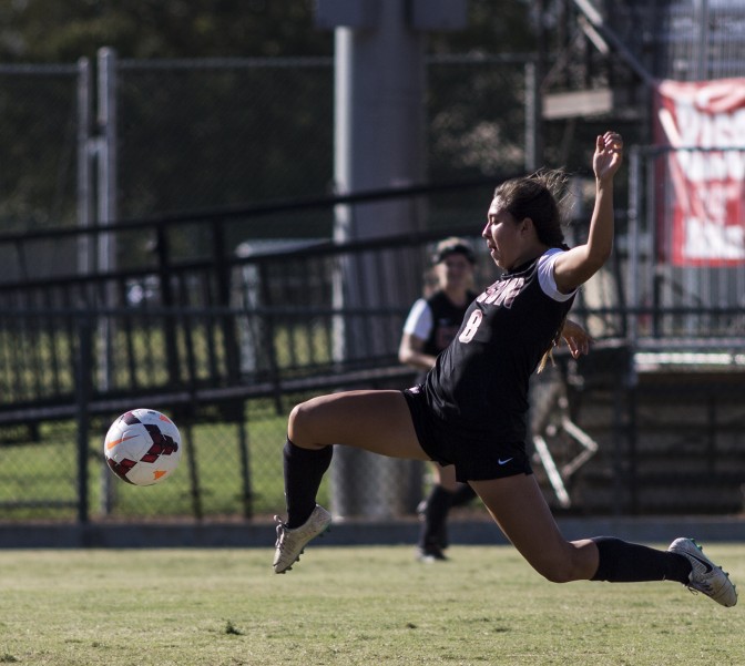 Women CSUN student maintains to keep the soccer ball balanced away from opposing team at Long Beach State University.
