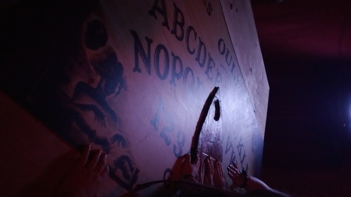 Spectators entertain themselves on a over sized Ouija board.
