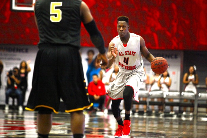 Freshman forward Tavrion Dawson (number 4) tries to run past opponent from Cal State L.A. (number 5).