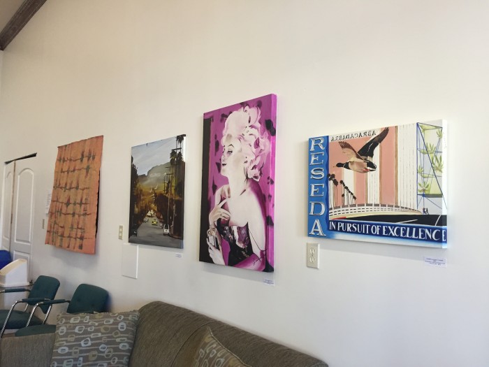 An art tour with three forms of art pinned up one wall. FIrst: a street perspective, a portrait of Marilyn Monroe and a scene of bridge and street with bird soaring over