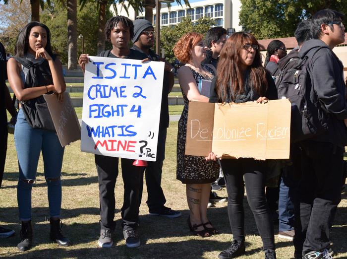 Students hold signs with messages to presdient Harris and show their discontent for the lack of diversity on campus at the Oviatt Lawn in CSUN on Wednesday, Nov. 18, 2015. (Raul Martienz / The Sundial)