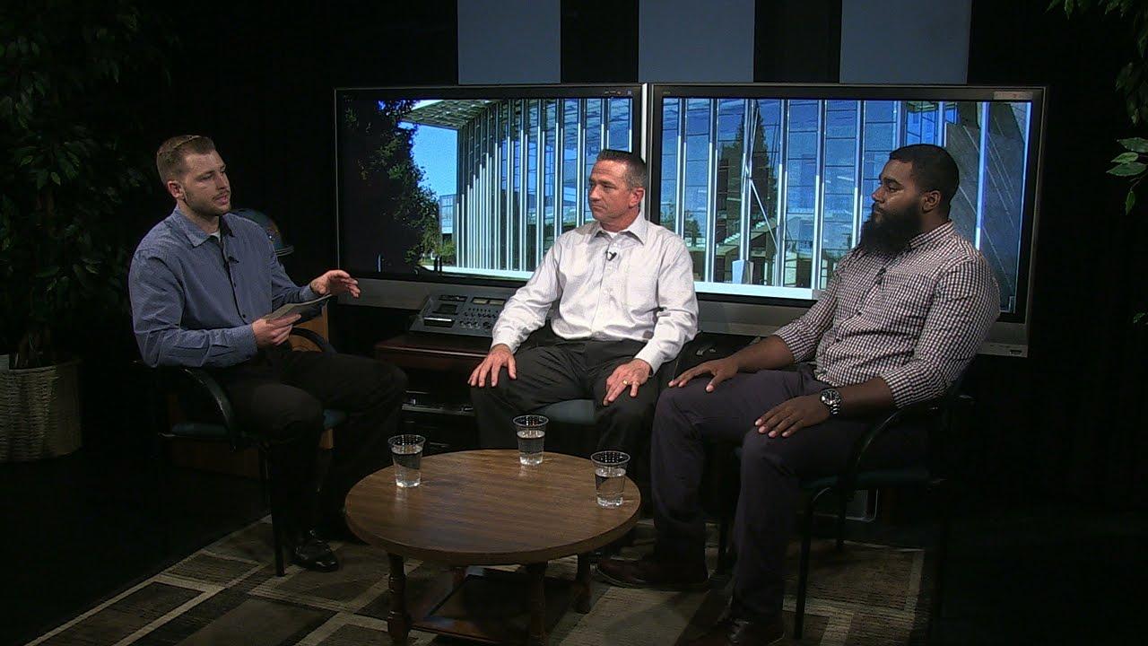 Three men sit along one another in interview