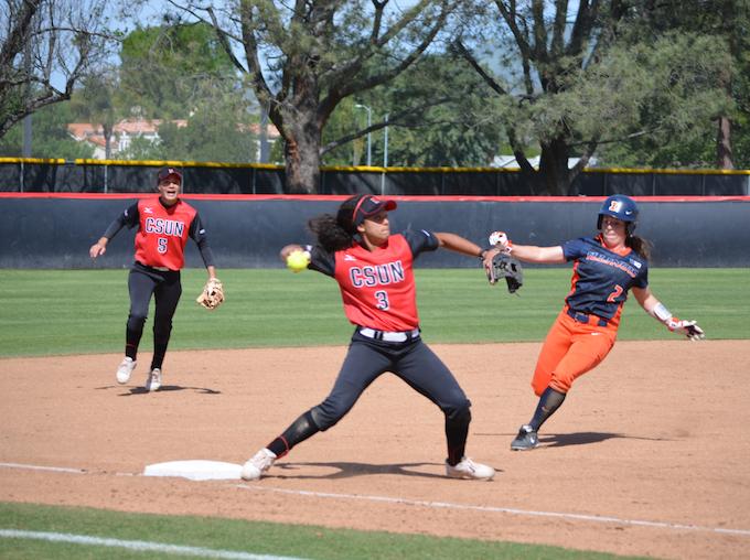 FILE PHOTO - Maylynn Mitchell (right) looks on as Tara Kliebenstein (center) makes the tag at third base and throws to first. Photo credit: Anthony Martinez