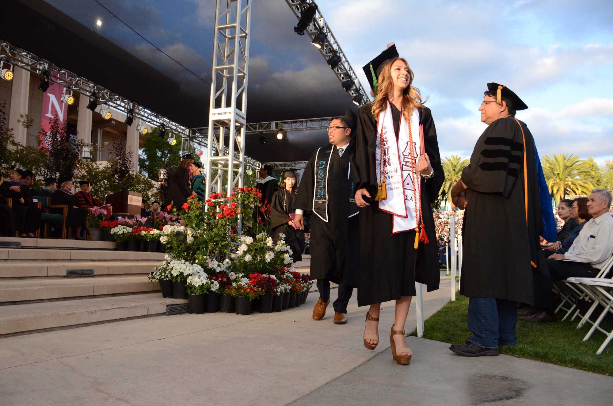 CSUN graduates walk off stage after greeting President Dianne Harrison during the College of Humanities and College of Health and Human Development on Monday, May 23. Photo credit: Erik Luna