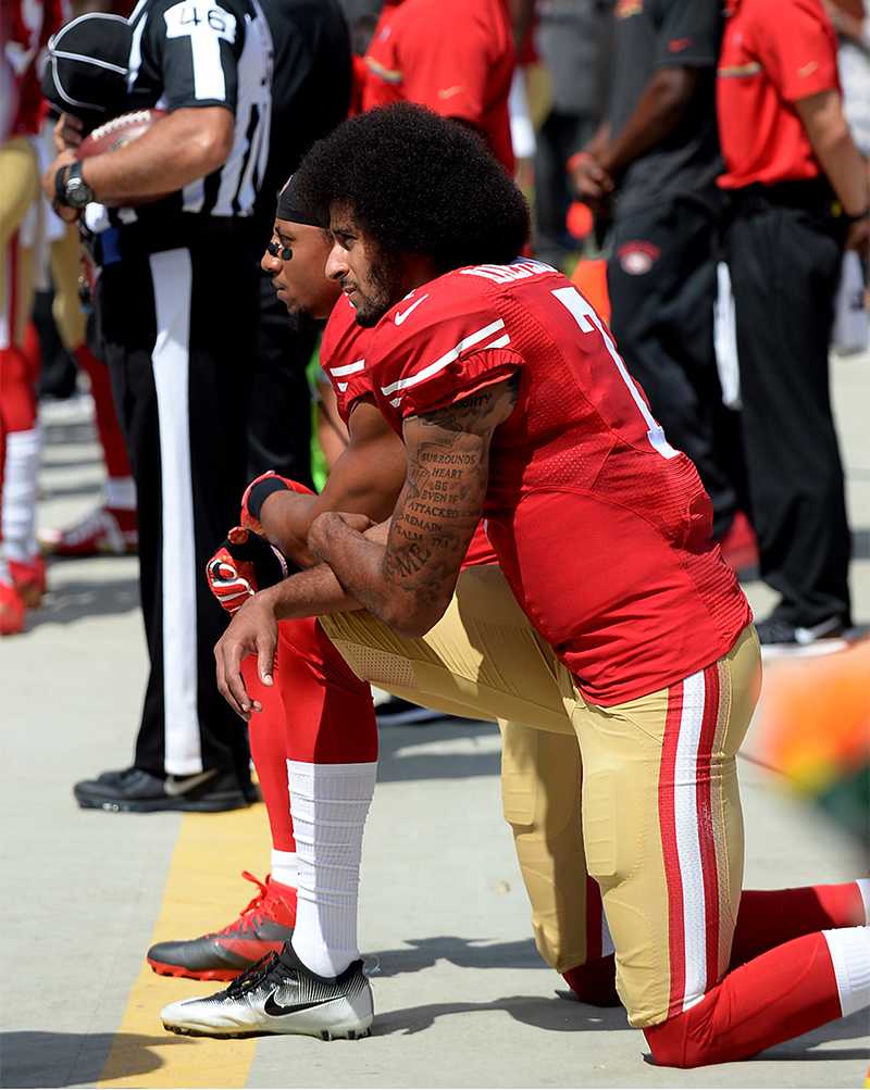 San Francisco 49ers quarterback Colin Kaepernick, front, and safety Eric Reid, back left, kneel during the playing of the national anthem on Sunday, Sept. 18, 2016 at Bank of America Stadium in Charlotte, N.C. (Jeff Siner/Charlotte Observer/TNS)