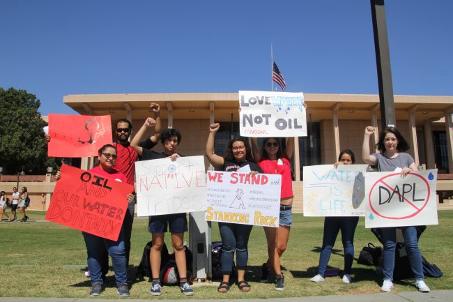 Members of the American Indian Student Association (AISA), (Left to Right) Melissa Urrea, Xavier Fierro, Kelly De Leon, Raven Freebird, Kristen Littlebird, Sara Suchite, and Shanna Nadybao, protested on the Oviatt Lawn to raise awareness of the Dakota Access Pipeline that threatens The Standing Rock Sioux Reservation's water supply.