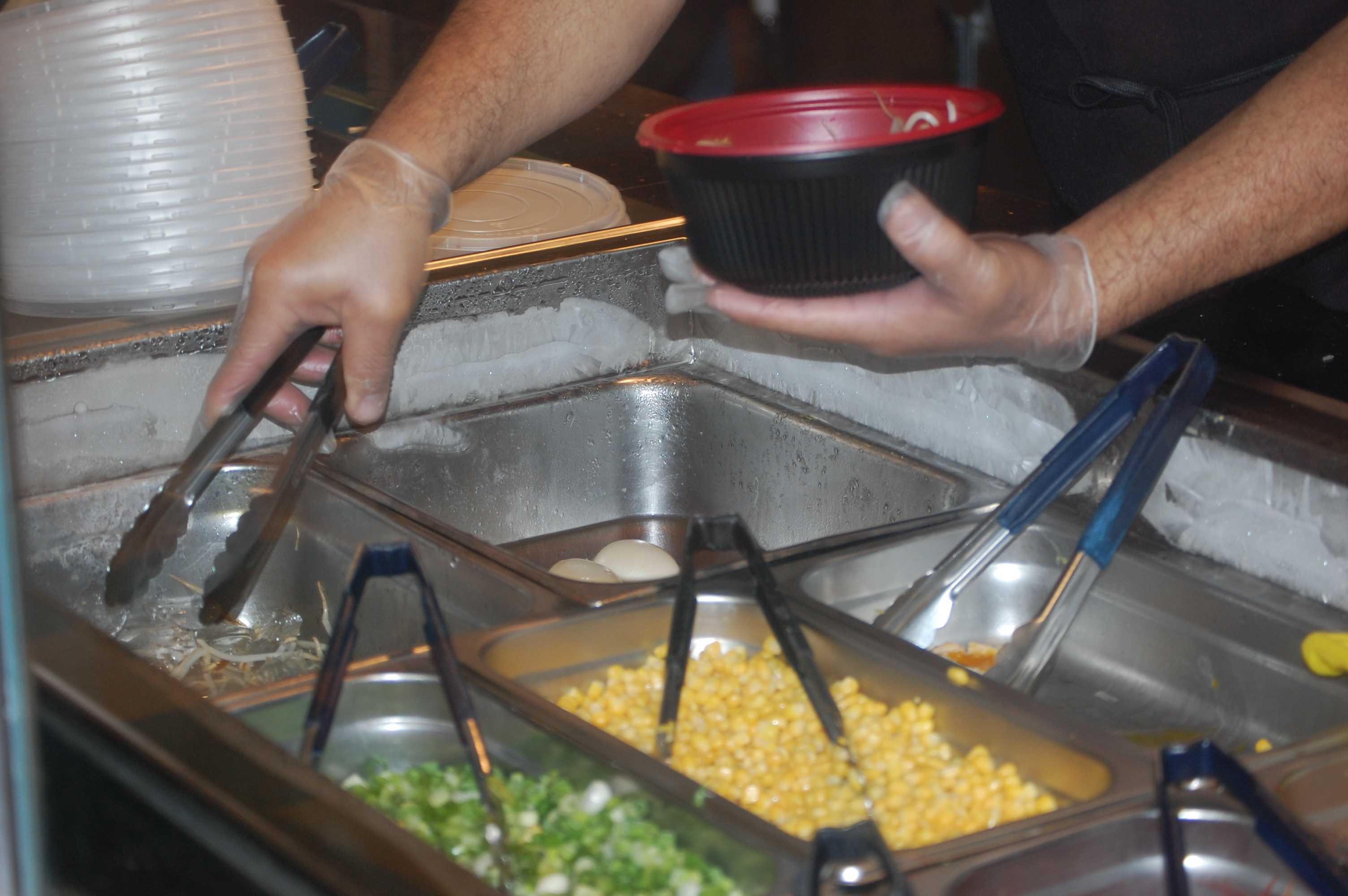 photo shows employee making poke bowl