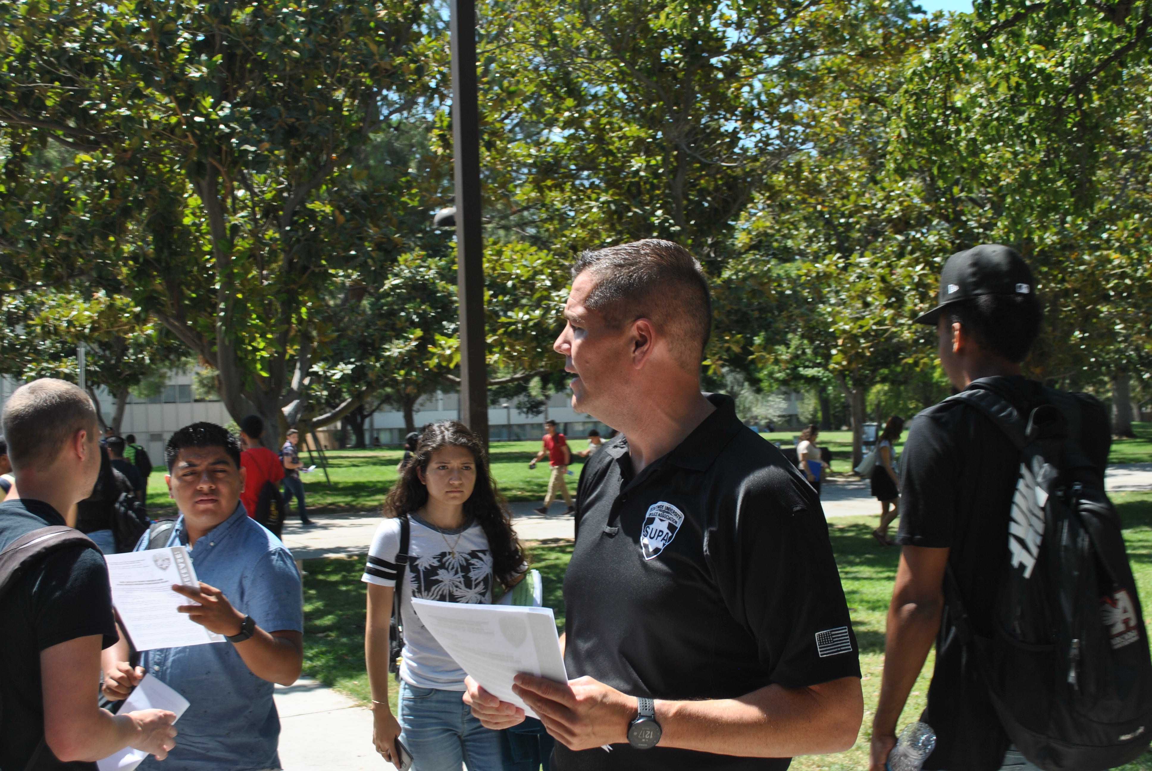 The President of the Statewide University Police Association (SUPA) Jeff Solomon hands out flyers and speaks to students about alleged parking citation quota. Photo credit: Blaise Scemama