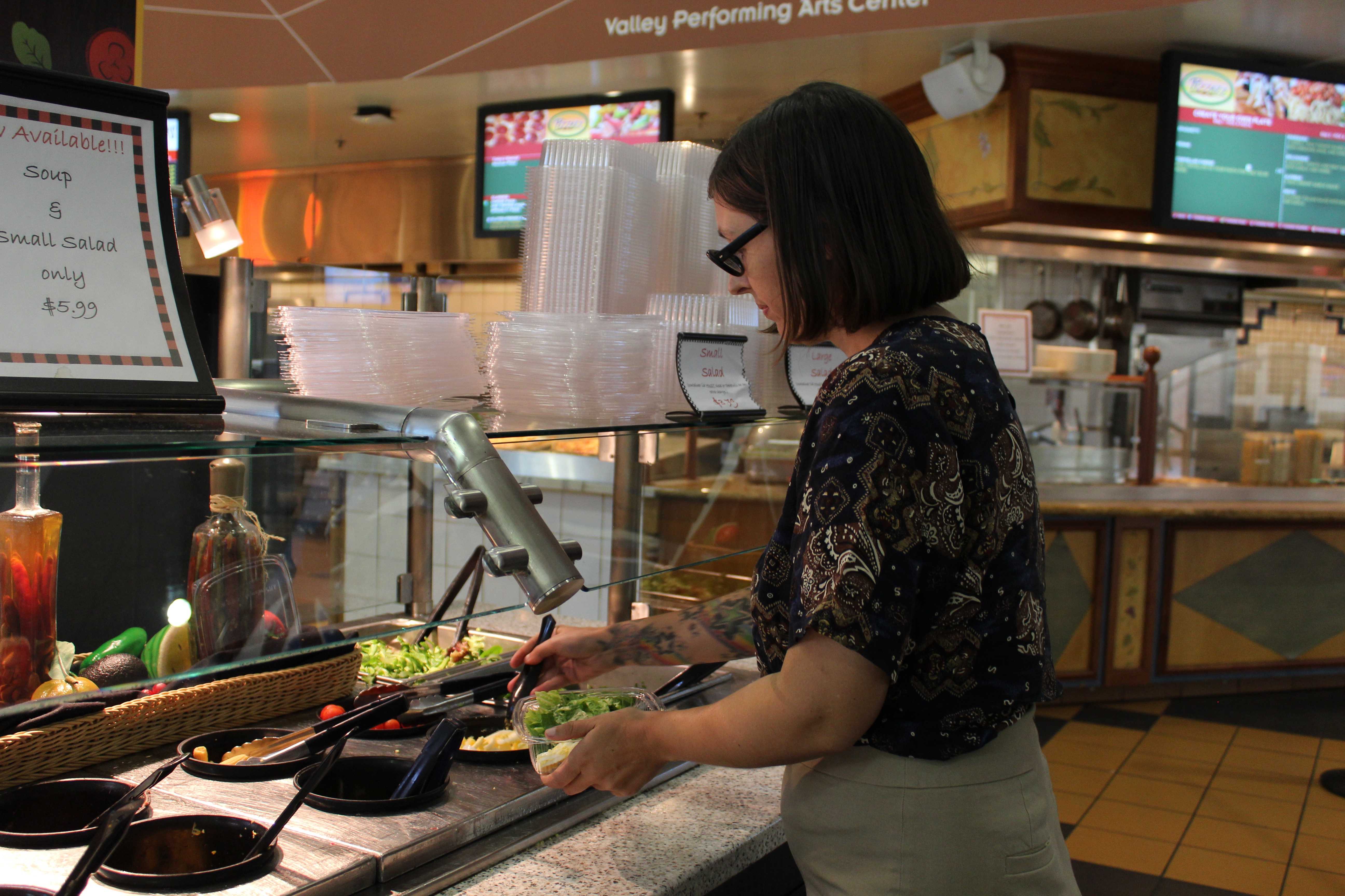 Woman helps herself at salad bar