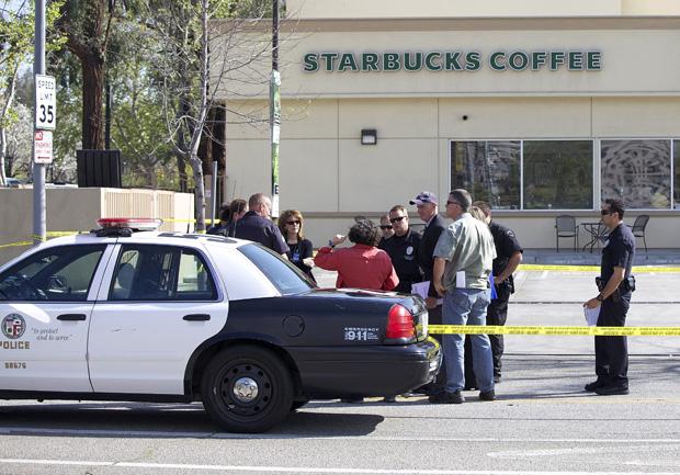 Police officers gather around people outside of starbucks