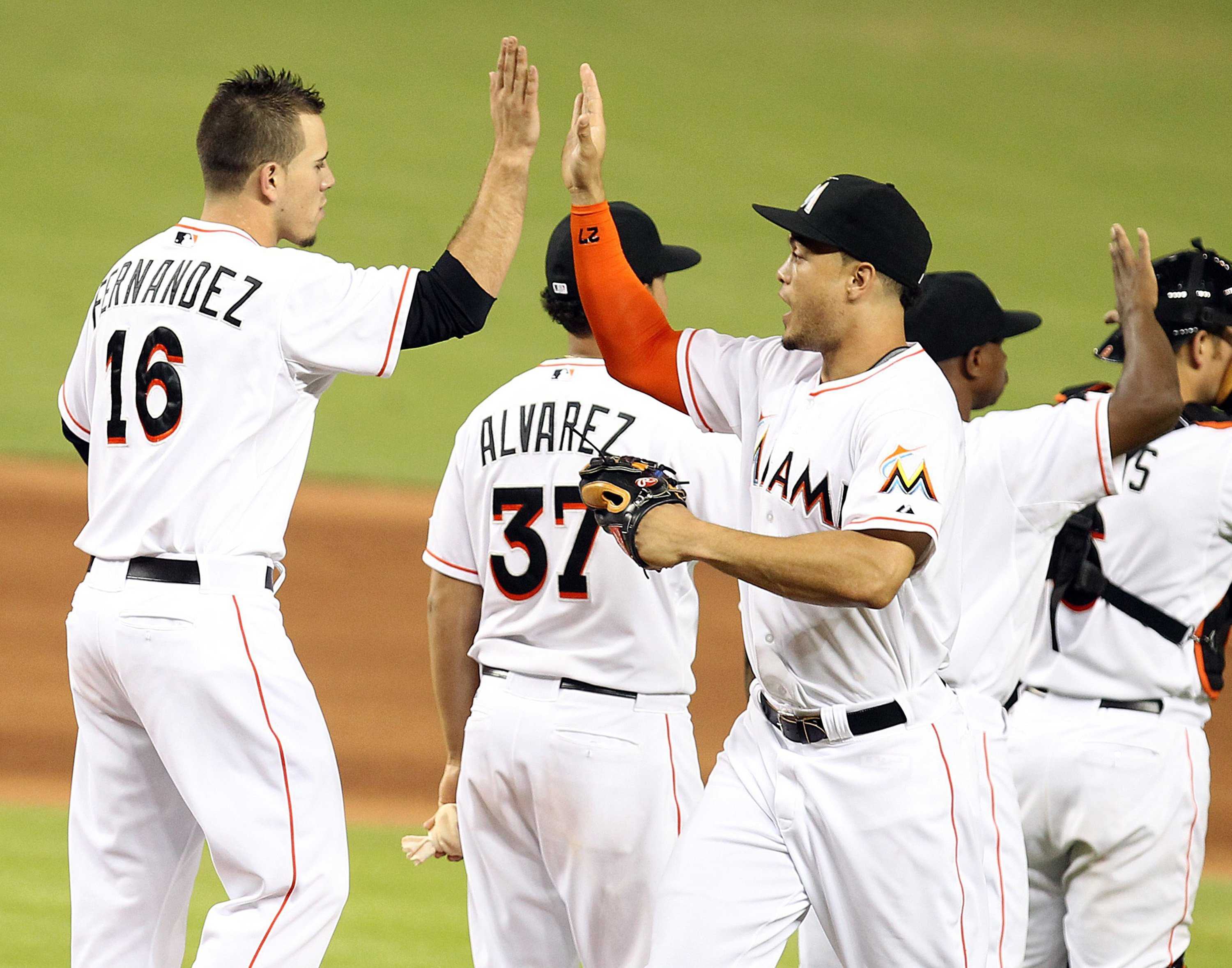 Miami baseball players high-five one another