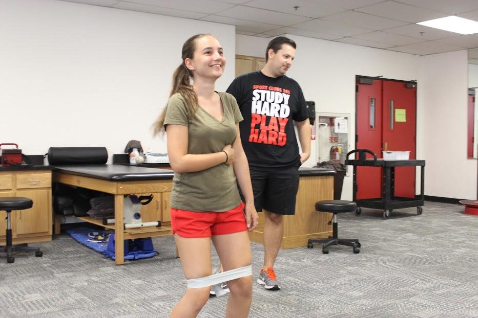 Athletic training intern Colin Lewis instructs ballroom dancer Aleks Trifonova who sustained patellar tendinitis and a hip injury. Photo credit: Robert Spallone