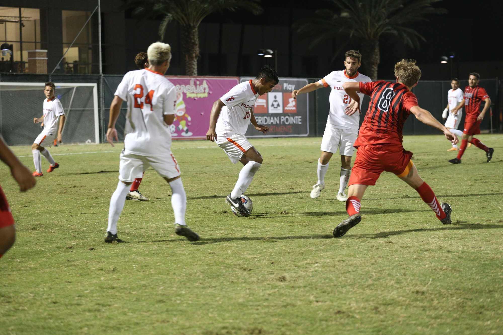 Jules Cailliau goes up against three Cal State Fullerton players in attempts to steal the ball and take it towards their goal on Oct. 12. Photo credit: Max Zeronian